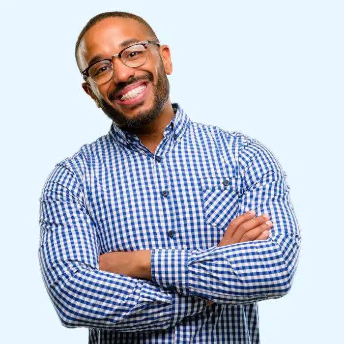 Smiling man with braces wearing a blue checkered shirt, representing adult orthodontic treatment benefits at Eagle Rock Orthodontics.