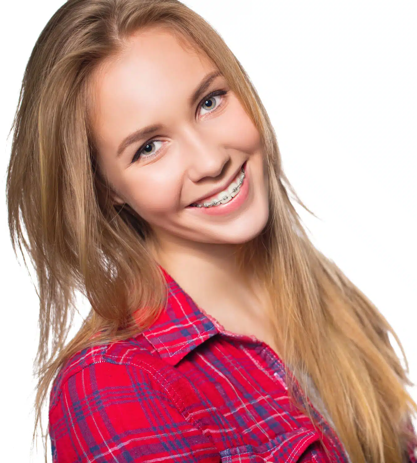 Smiling young woman with braces wearing a red plaid shirt, representing orthodontic care and treatment benefits.