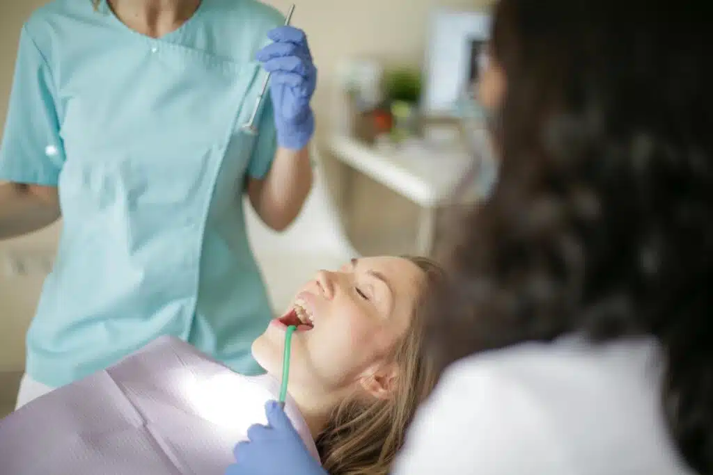 Patient undergoing clinical exam at orthodontist office, with orthodontist examining teeth and discussing treatment options.