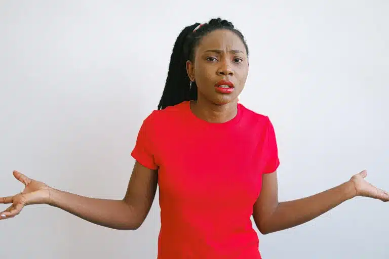 Woman in a red shirt expressing confusion or frustration, illustrating the importance of asking questions during your first orthodontic visit at Eagle Rock Orthodontics.