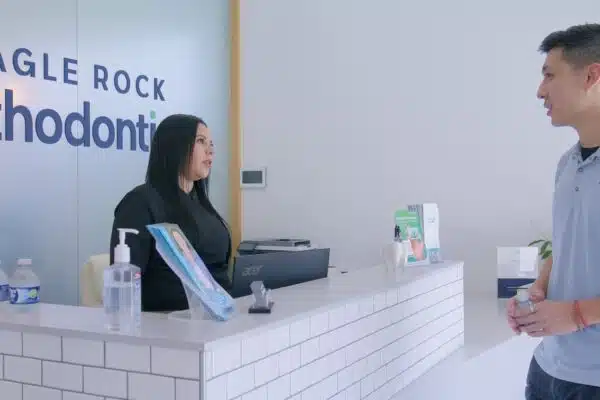 Reception area at Eagle Rock Orthodontics with staff member assisting a patient, showcasing a welcoming environment for orthodontic consultations and financial discussions.