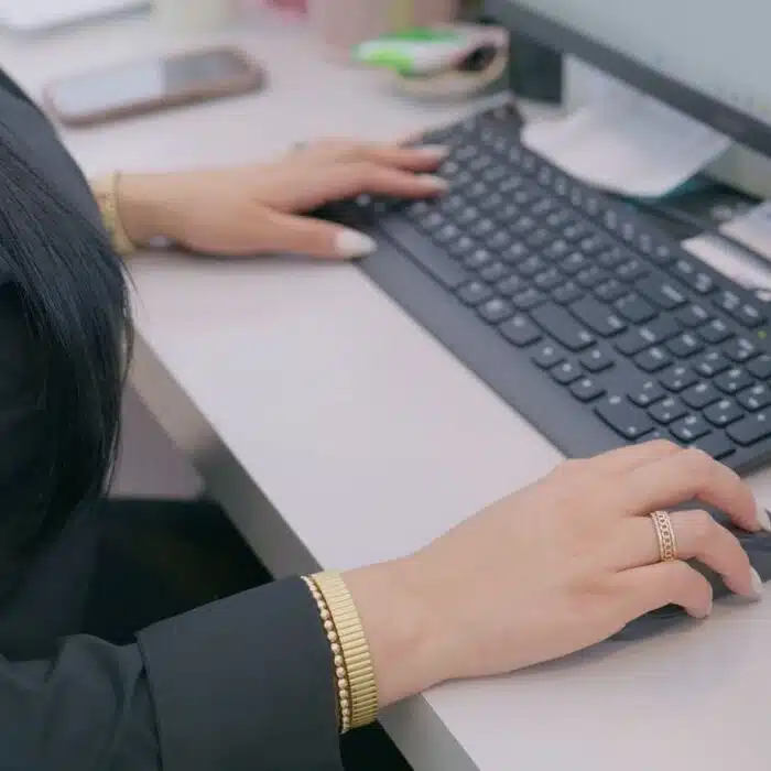 Hand on keyboard in an office setting, indicating administrative support for orthodontic financial options and consultations at Eagle Rock Orthodontics.