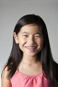 Smiling girl with braces, showcasing dental treatment benefits for children at Eagle Rock Orthodontics.