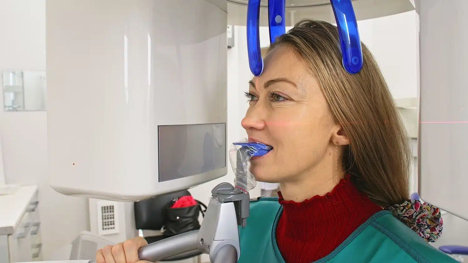 Woman undergoing digital imaging in orthodontic office, wearing protective gear and a mouthpiece, illustrating modern adult orthodontic assessment techniques.