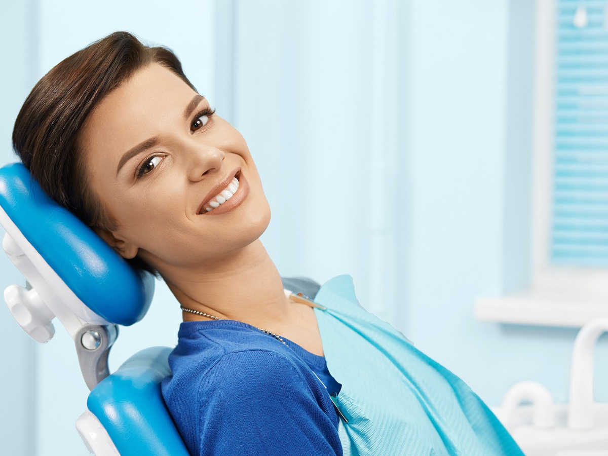 Adult patient smiling in a dental chair, representing adult orthodontic health benefits